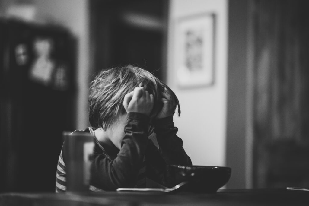 Church Hurt Is Real: 7 Powerful Truths That Can Heal What Religion Broke 3 Child sitting with head in hands, expressing sadness and overwhelm