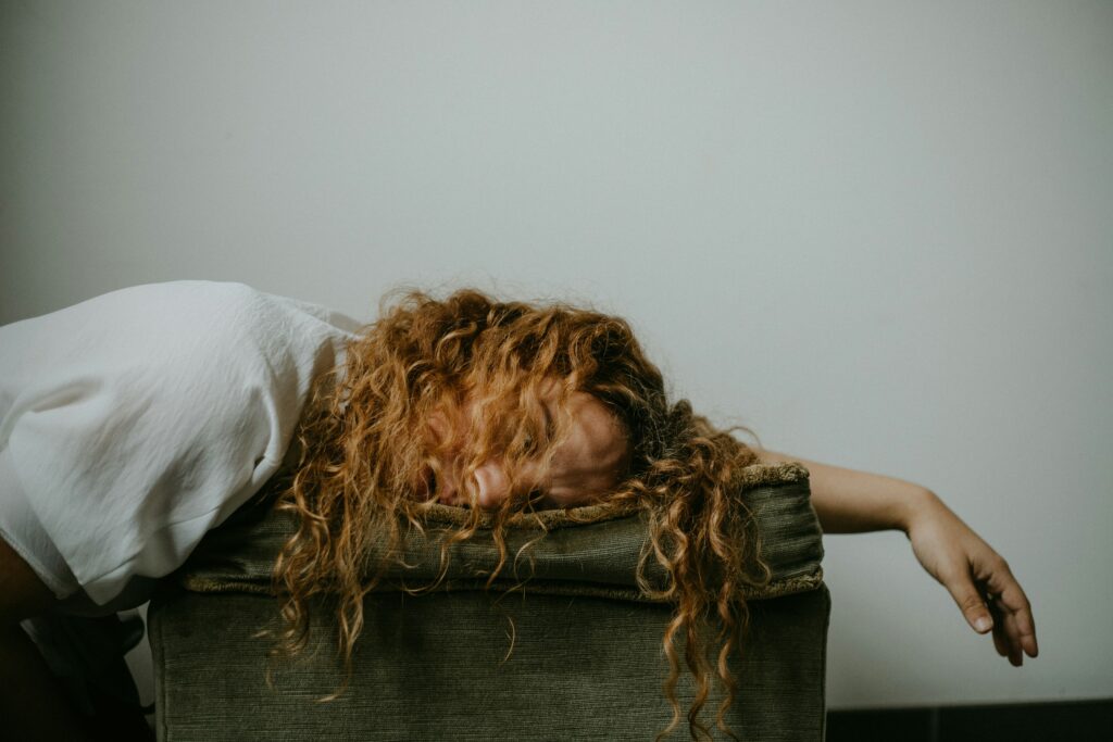 7 Life-Changing Reasons to Stop Striving and Start Living in God’s Freedom 2 Exhausted woman collapsed on a chair, symbolizing the emotional toll of spiritual striving